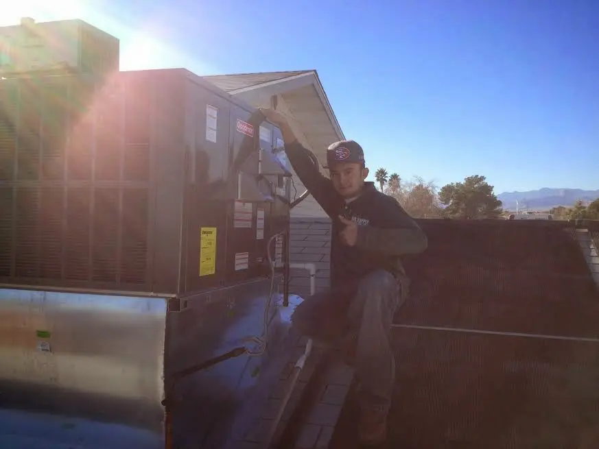 HVAC technician performing HVAC Inspection on a rooftop unit in Ruidoso